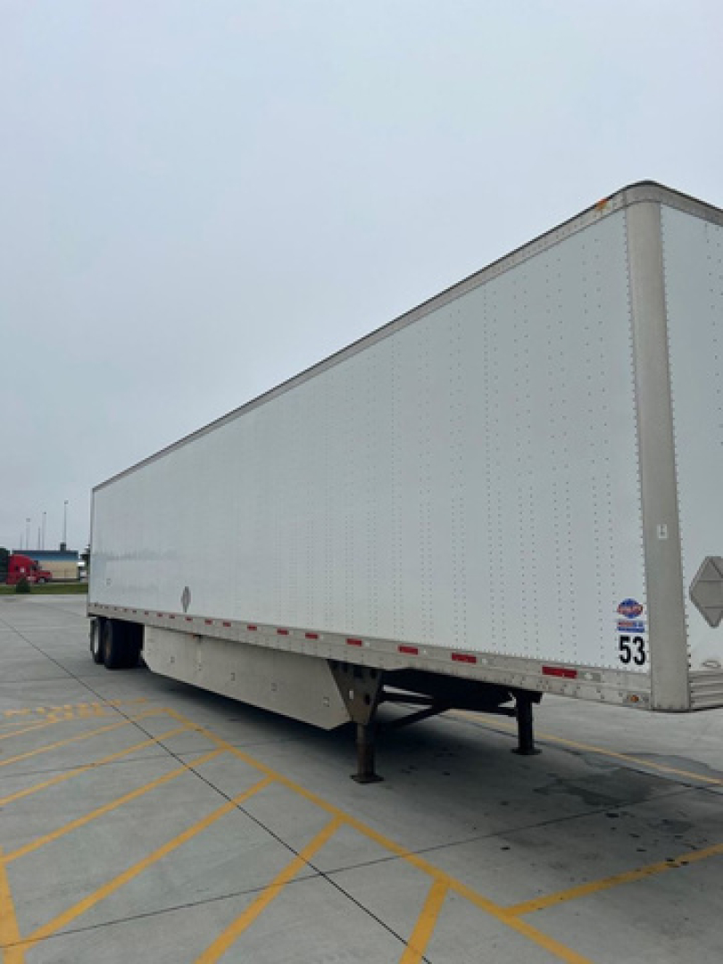 Utility van trailer showing side view with landing gear and number 53 sticker.