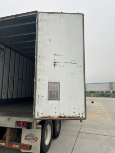 Trailer rear of a 2014 Utility Van showing open cargo area and aluminum exterior with vent on door.