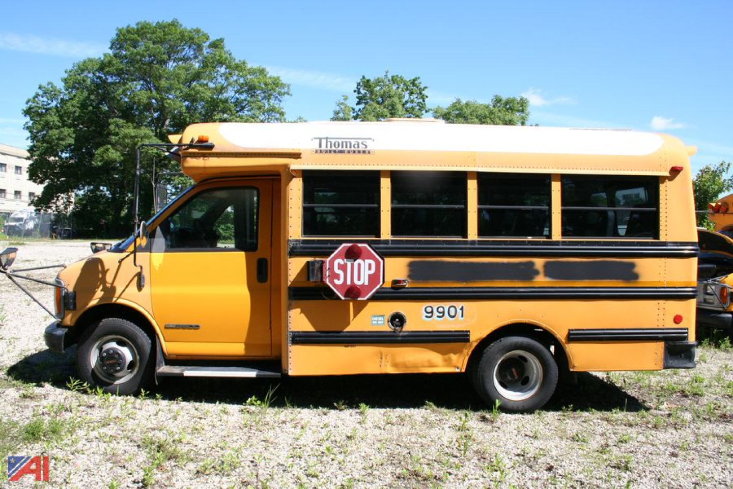 School bus side view showing Thomas logo atop the yellow body and stop sign extended.