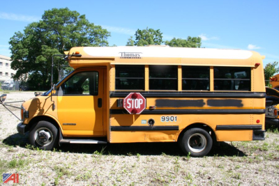 School bus side view showing Thomas logo atop the yellow body and stop sign extended.