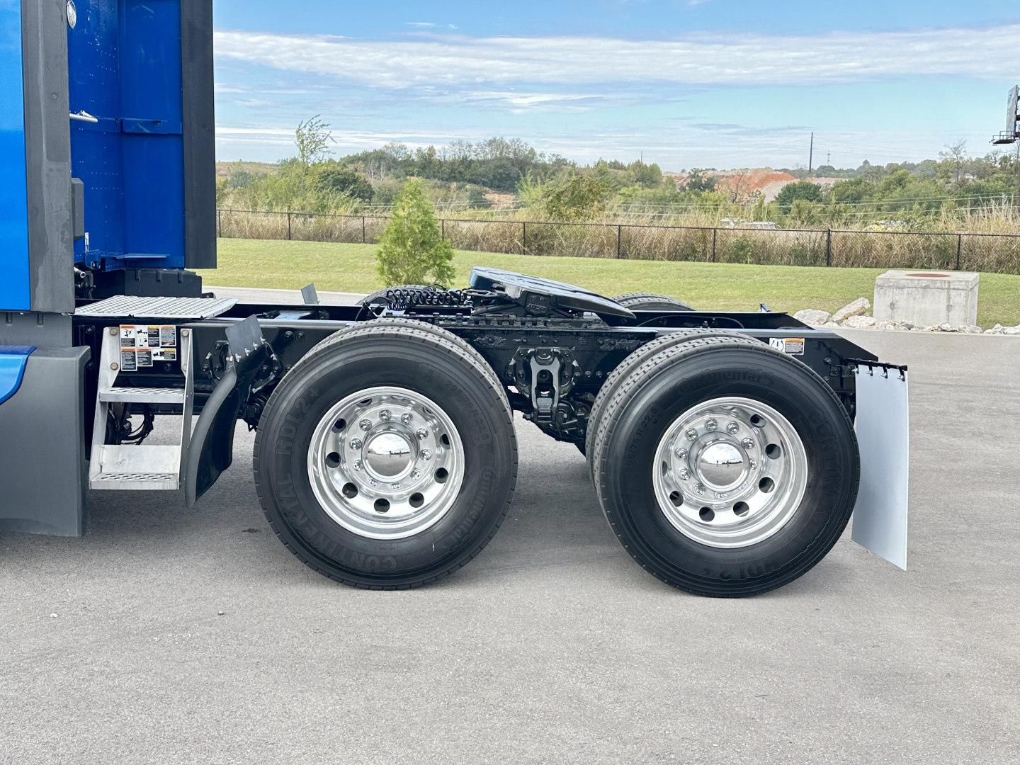 Dual rear wheels on an empty trailer chassis of a Kenworth T680 truck showing the axle assembly and tires.