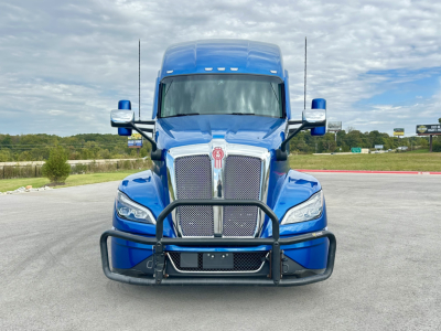 Kenworth T680 conventional sleeper front view showing chrome grille, blue cab, and heavy-duty grille guard.