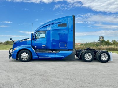 Kenworth T680 sleeper tractor in blue, side view showing cab and rear wheels, VIN plate not visible.