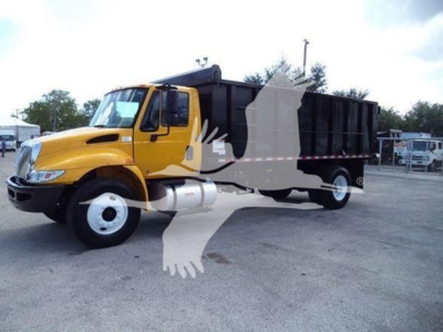 Truck with yellow cab and black dump bed seen in a parking lot