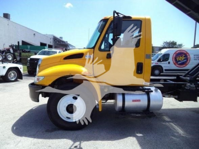 Truck cab side view of a yellow 2019 International 4300 dump truck with white front wheel and side fuel tank.