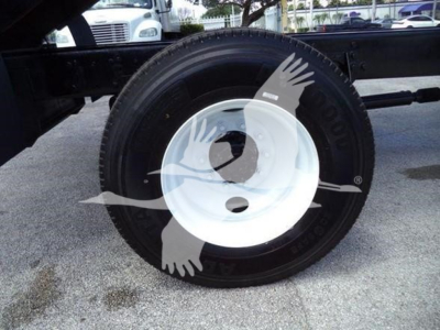 Wheel and tire assembly of a 2019 International 4300 dump truck showing a white steel wheel and black tire with sidewall markings.