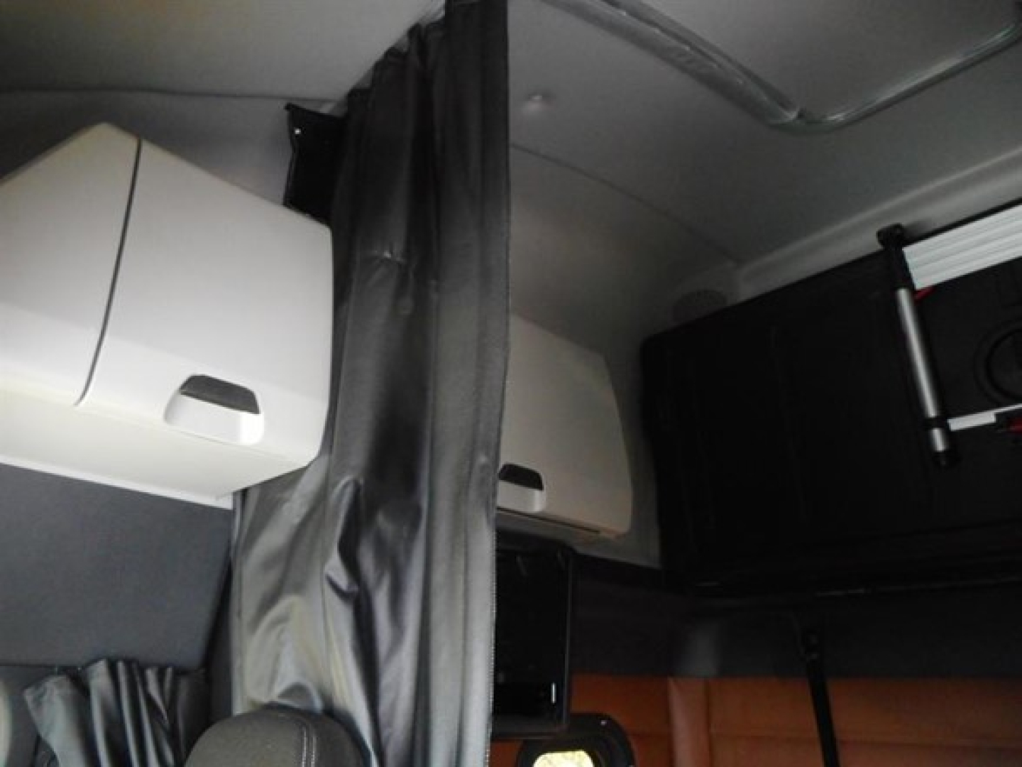 Cabin interior of a Freightliner Cascadia 126 sleeper showing storage compartments and partitions.