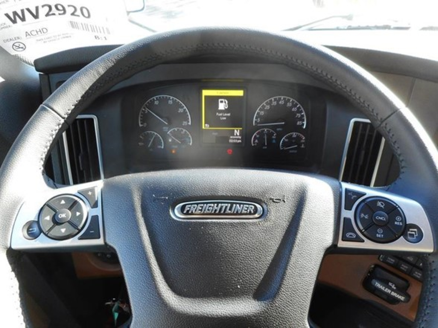 Freightliner Cascadia 126 truck interior steering wheel and instrument cluster with center display showing warning icon and gauges.