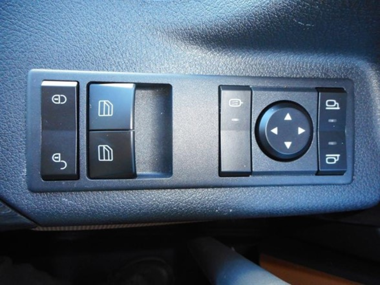 Tractor cab door/controls panel showing window and mirror adjustment switches in a Freightliner Cascadia interior.