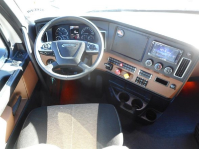 Freightliner Cascadia 126 truck interior showing steering wheel, dashboard, touchscreen display, and control panel.