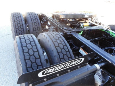 Freightliner Cascadia 126 truck chassis showing rear drive tires and frame with Freightliner mudguard graphic.