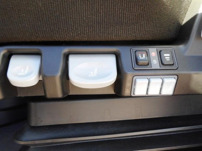 Seat and control panel in cab showing seat heater controls and window switches in a Freightliner Cascadia interior.