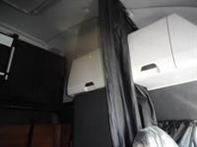 Interior cab area of a Freightliner Cascadia showing overhead sleeper compartments and storage panels.