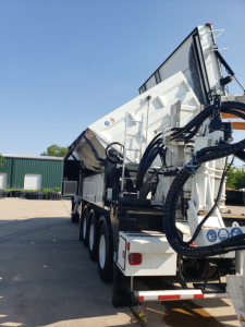 Volvo VHD86B300 truck with large trenching attachment mounted at rear, multiple axles, hydraulic hoses and control panels visible.