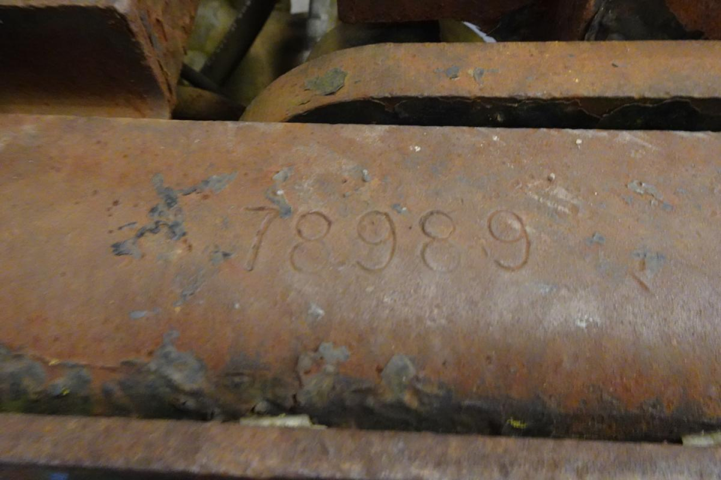 Close-up of a stamped number 78989 on a rusted metal surface, indicating a VIN/stock tag on a yard truck.