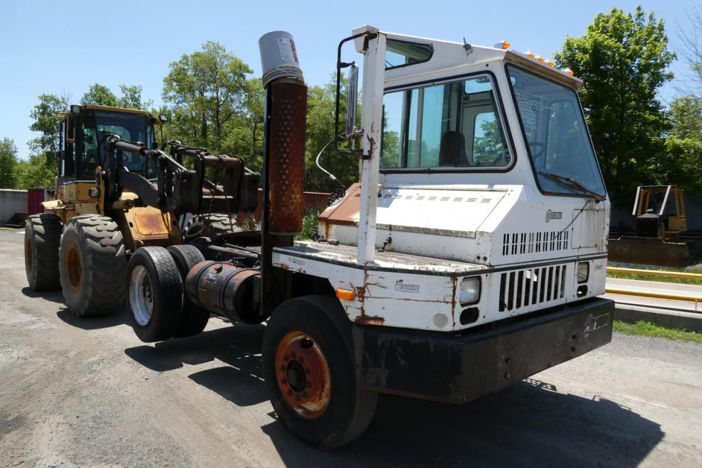 Used Ottawa yard truck with white cab and attached heavy equipment, side vents, and orange rims; VIN 78989 visible in listing.