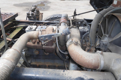 Truck engine bay showing large exhaust manifold and air intake piping in a used Ottawa yard truck.