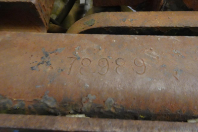Close-up of a stamped number 78989 on a rusted metal surface, indicating a VIN/stock tag on a yard truck.