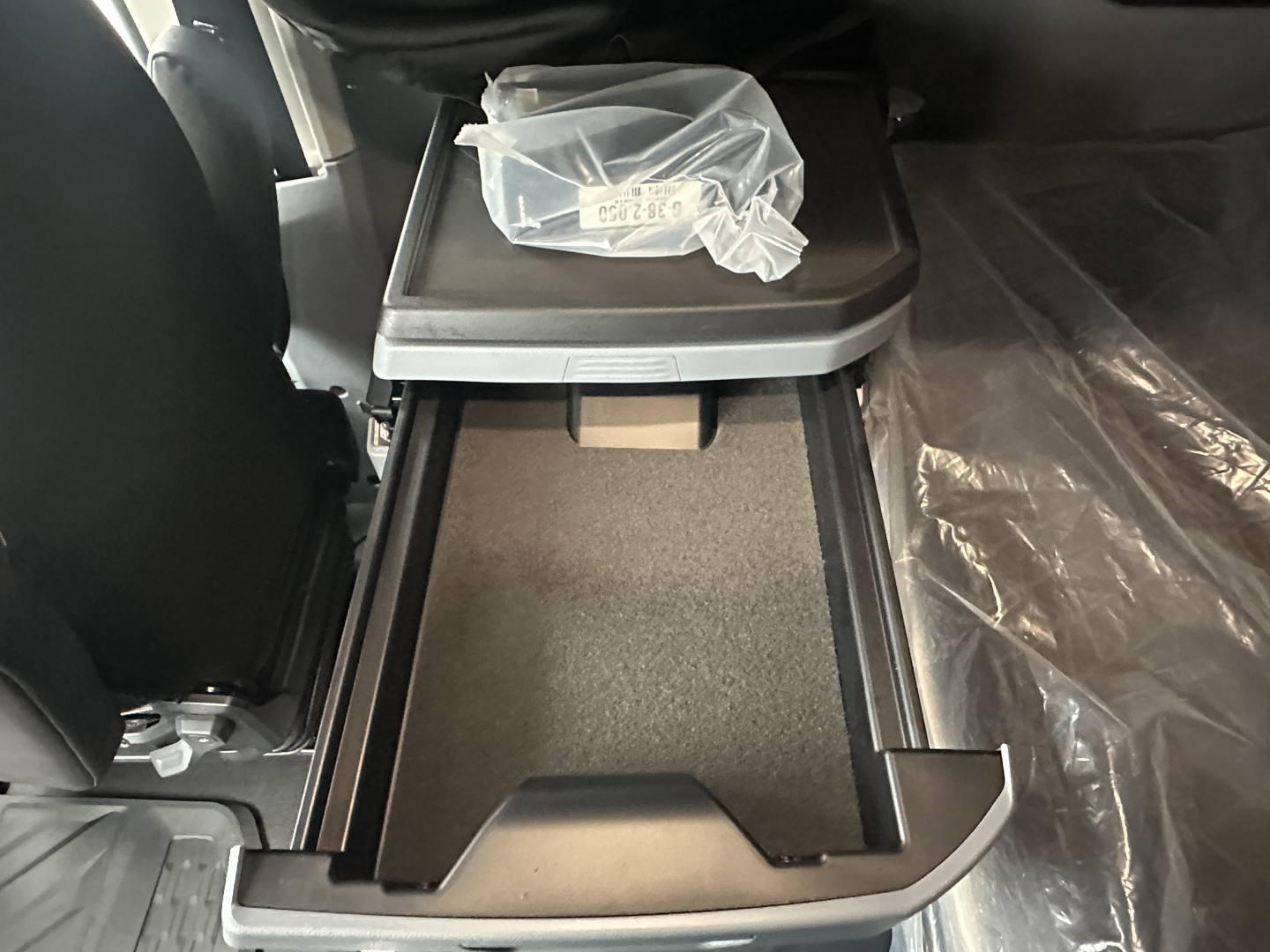 Mack PR64T76H truck interior showing center console storage with open storage bin and cup holder area.