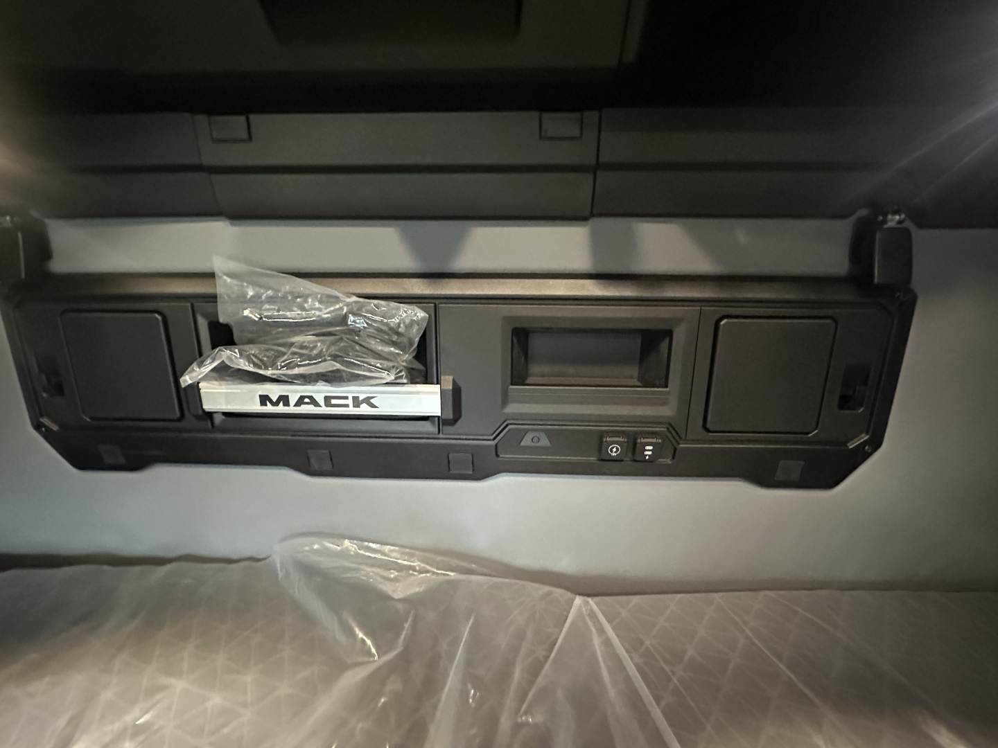 Mack PR64T76H dash area showing storage compartment and control panel.