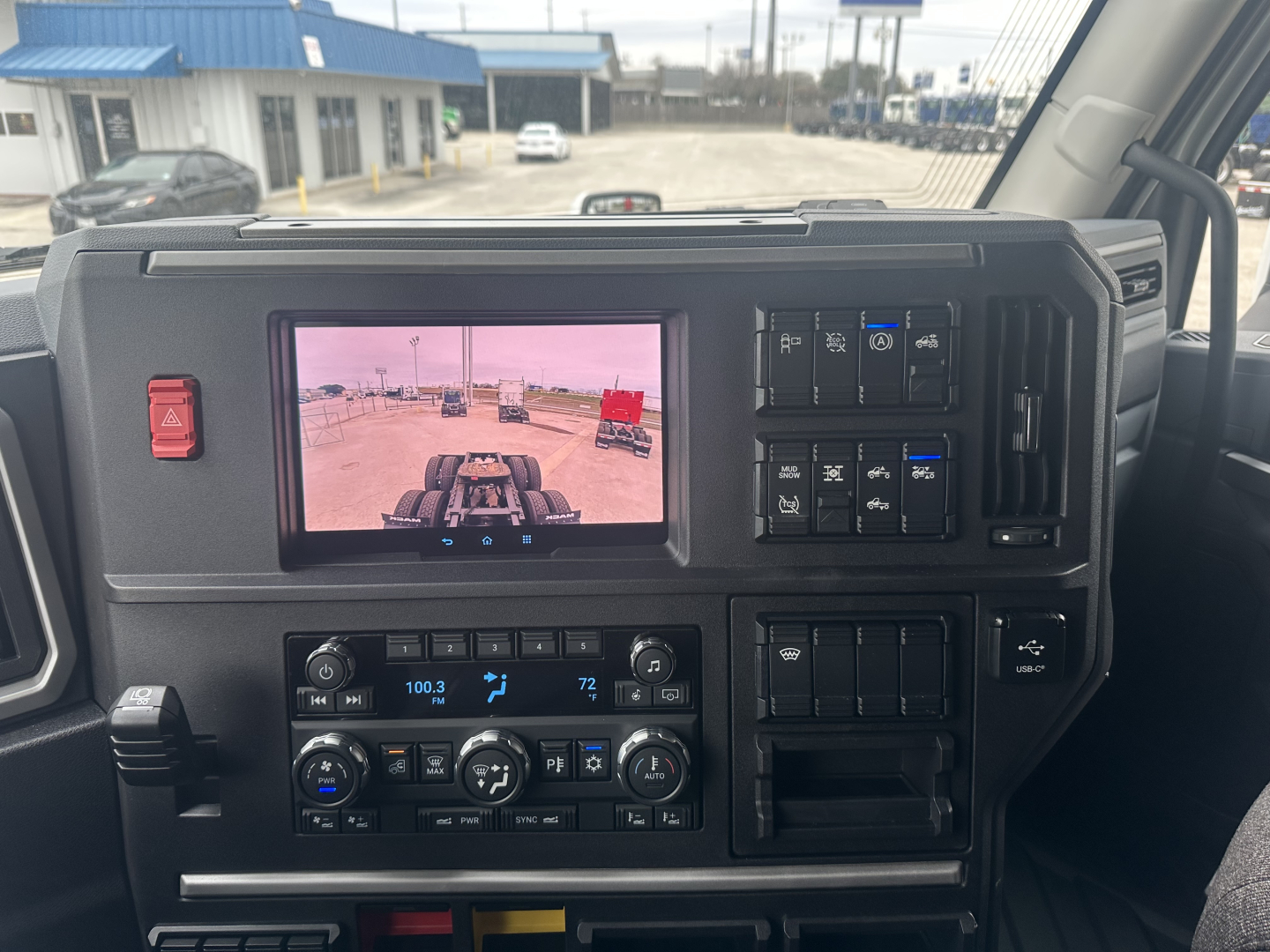 Dashboard of a Mack PR64T76H sleeper tractor showing infotainment screen, climate controls, and various switches.