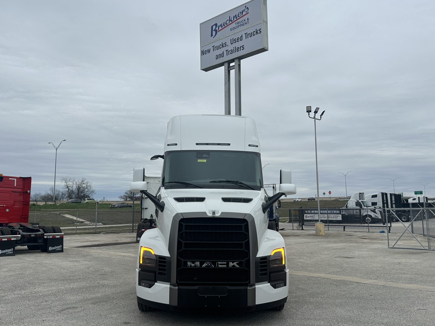 Mack PR64T76H conventional sleeper truck front view with illuminated daytime running lights.