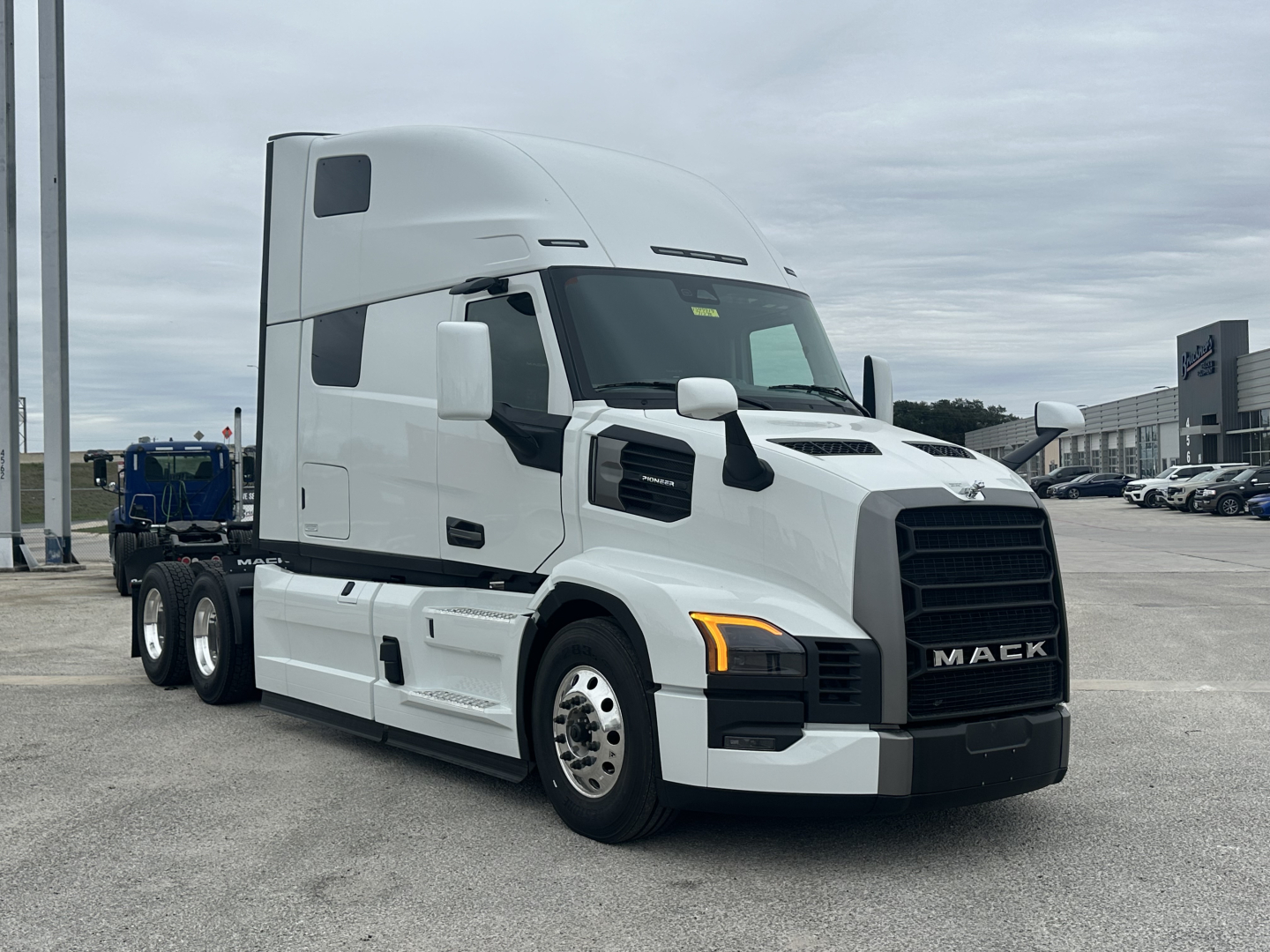 Mack PR64T76H sleeper tractor truck in white, front three-quarter view showing cab, hood, and grille with Mack badge.