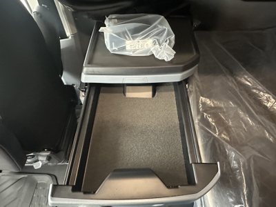 Mack PR64T76H truck interior showing center console storage with open storage bin and cup holder area.