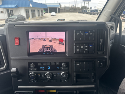 Dashboard of a Mack PR64T76H sleeper tractor showing infotainment screen, climate controls, and various switches.