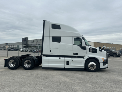 White Mack PR64T76H conventional sleeper tractor shown in side view with dual rear axles and fuel tanks visible.