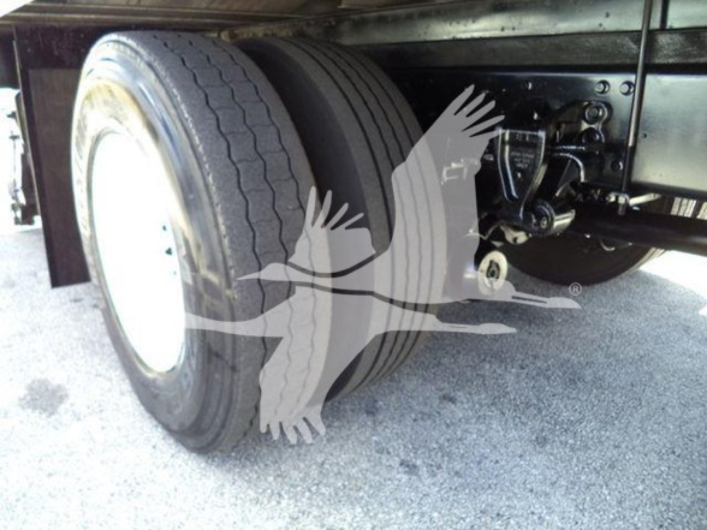 Rear axle and dual tires of a refrigerated truck showing tandem wheels and suspension components