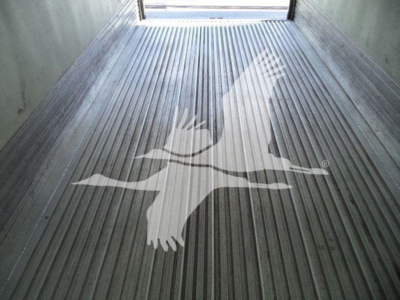 Tractor-trailer bed with metal ribbed floor and a large white silhouette decal of a flying bird in the center.