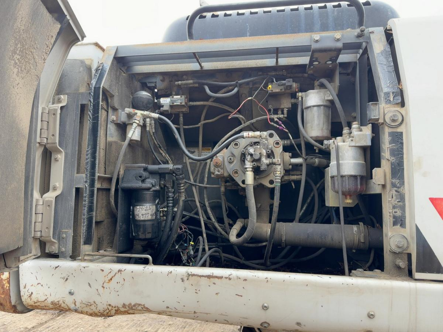 Excavator engine bay showing hydraulic pumps and wiring for a 2007 Link-Belt 330LX with exposed components and hoses.