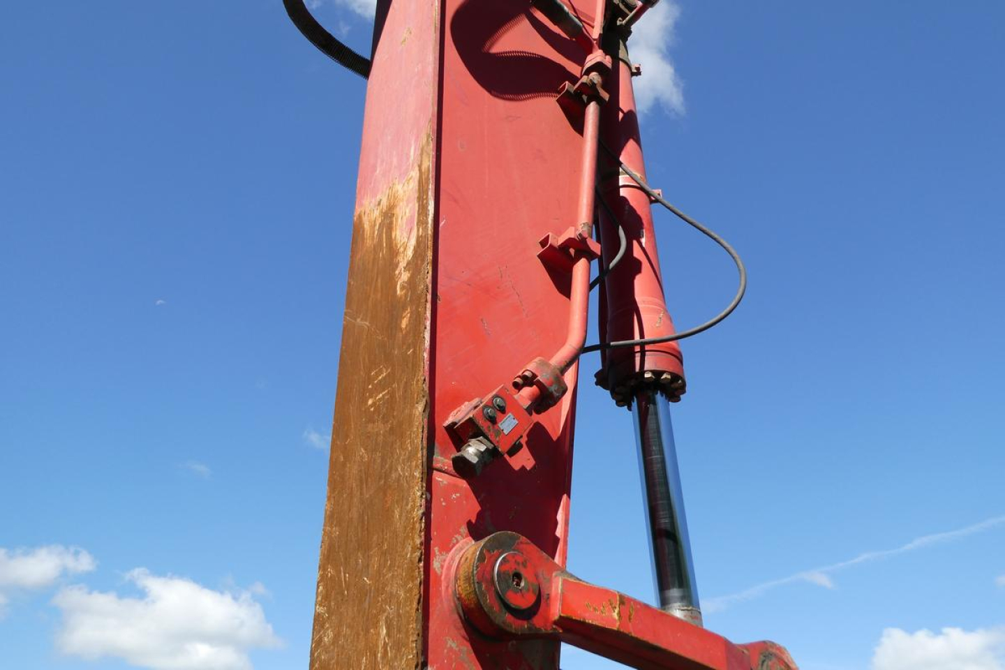 Link-Belt 330LX boom section with hydraulic cylinder and pins against a blue sky.