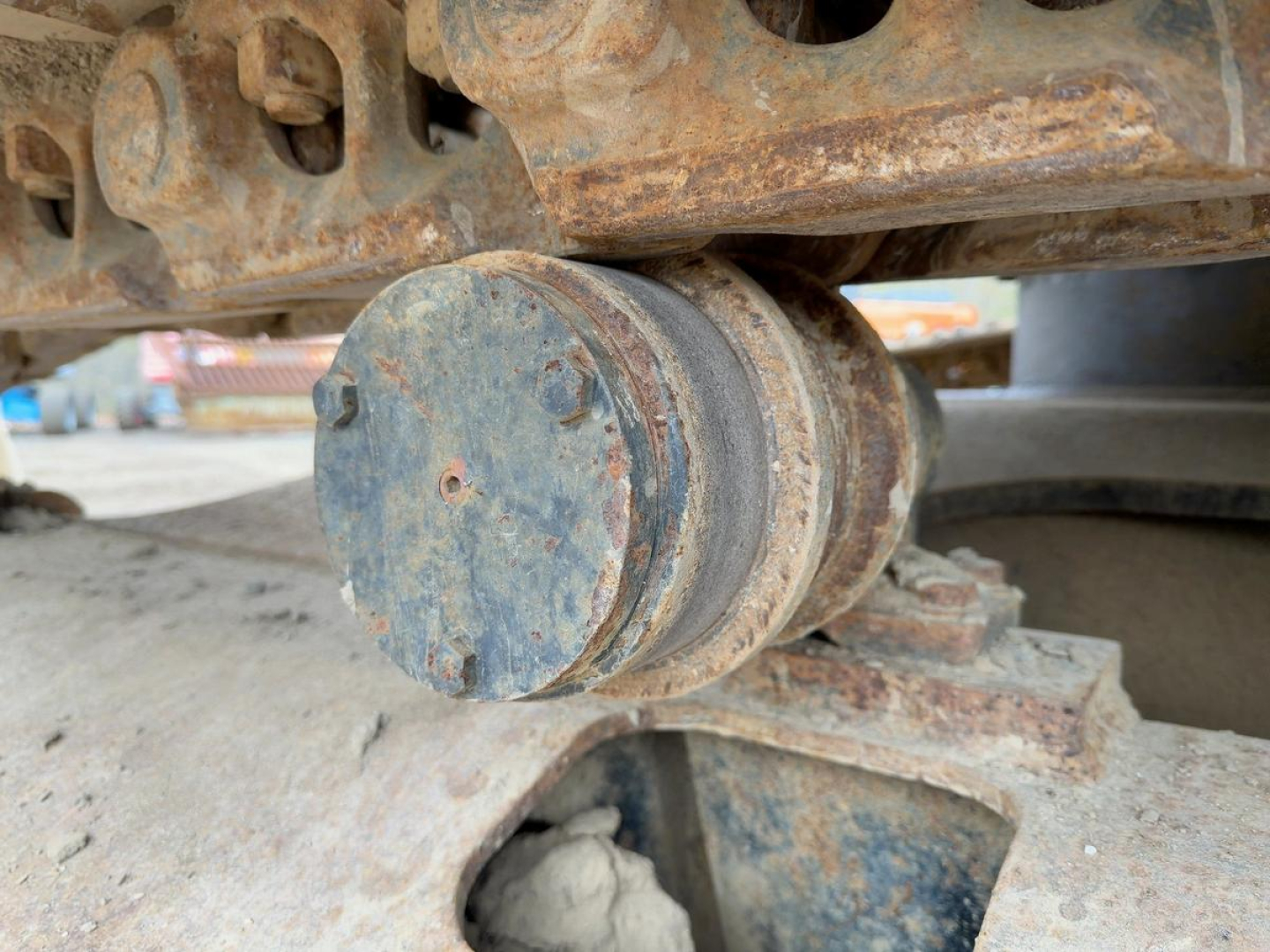 Link-Belt excavator track roller showing rust and mechanical hub near undercarriage.