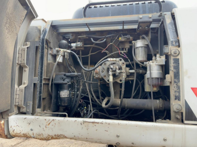 Excavator engine bay showing hydraulic pumps and wiring for a 2007 Link-Belt 330LX with exposed components and hoses.