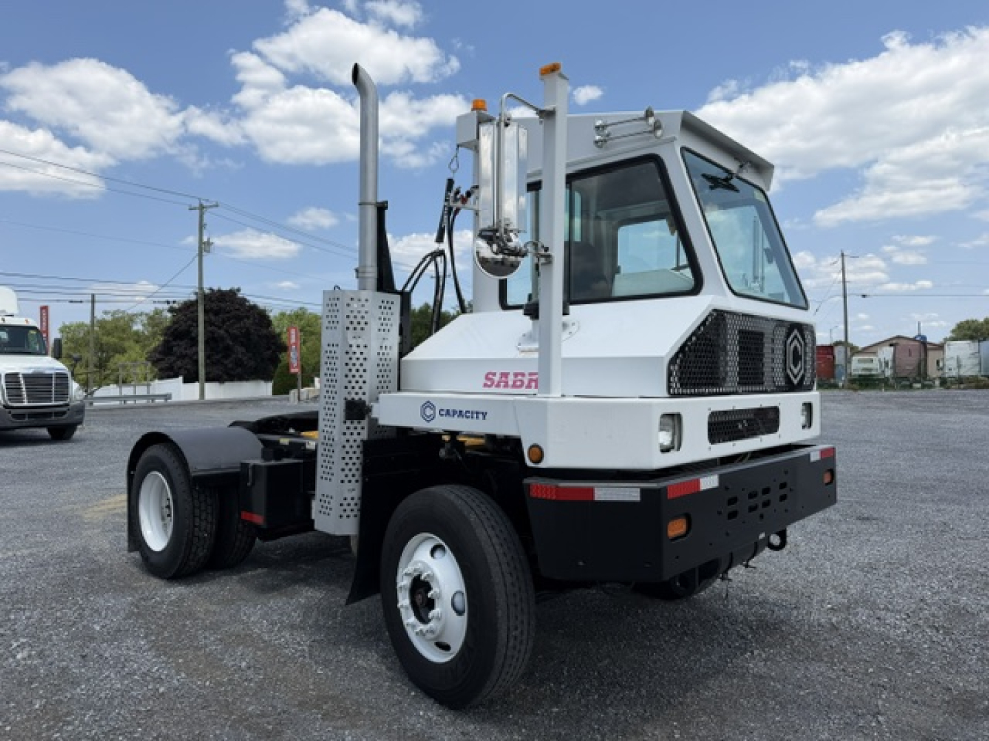 front-left view of a 2018 Capacity Sabre DOT yard truck showing cab, twin exhaust stacks, capacity label, and wheel.