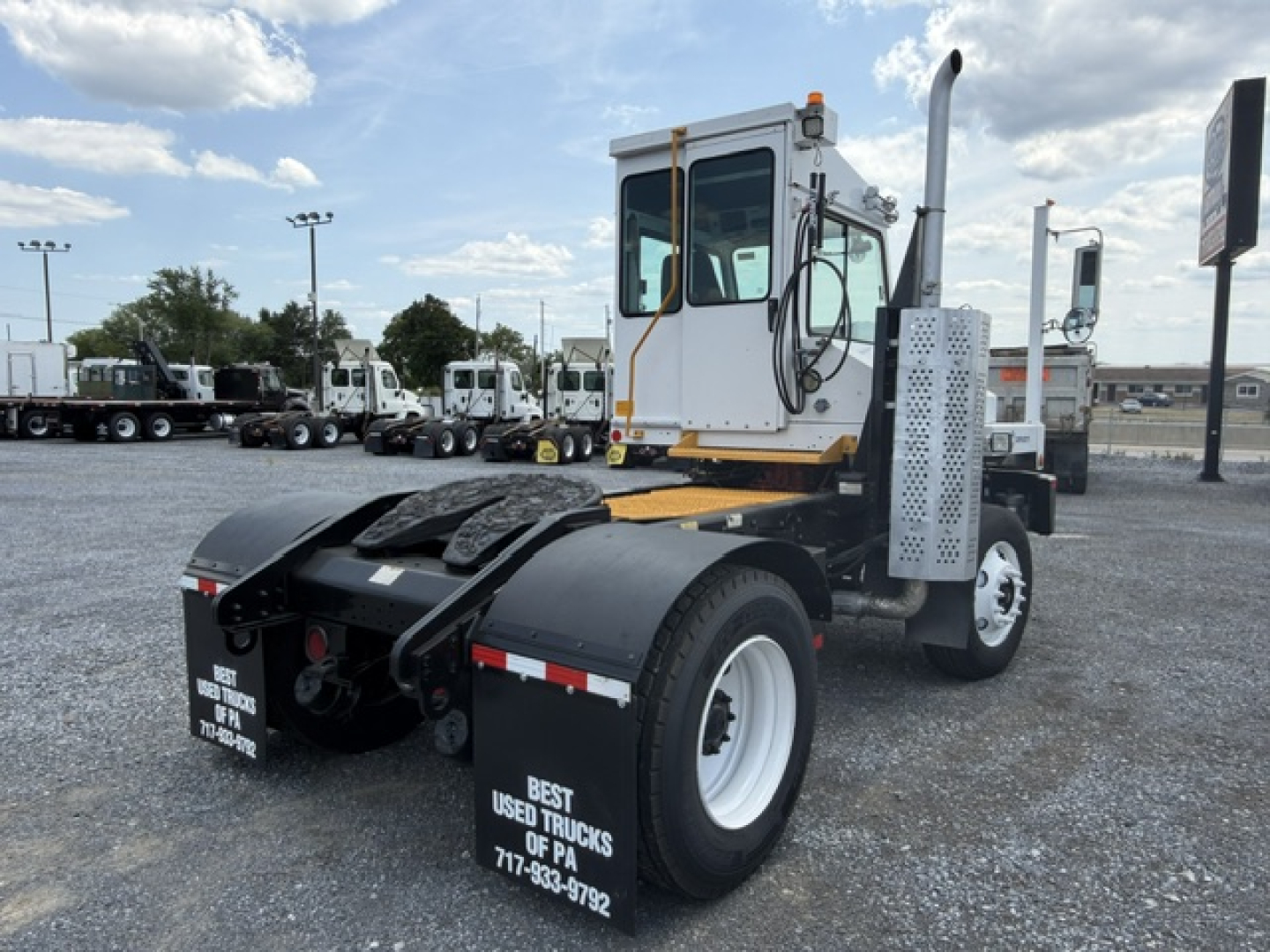 Tractor cab view of a white capacity Sabre DOT yard truck with large dual rear wheels and black fenders, showing fuel/air lines and demand label; photo focuses on cab and chassis.
