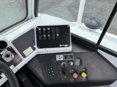 Dashboard panel with switches and gauges in a passenger bus cab showing control switches and knobs