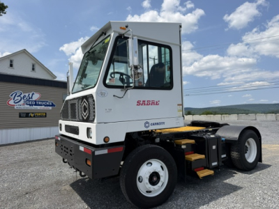 Truck cabin showing capacity sabre logo, white cab, front grille, and steps; DOT yard use vehicle with single rear axle and cab-over design.