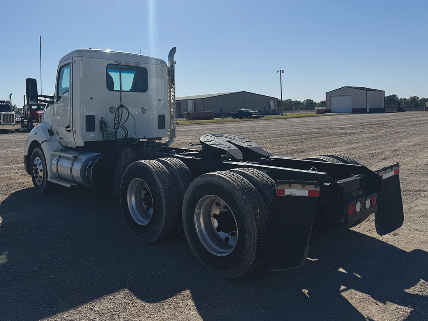 Kenworth T680 tractor rear and cab side view showing dual rear axles, fifth wheel mount, and fuel tanks