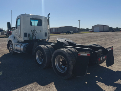 Kenworth T680 tractor rear and cab side view showing dual rear axles, fifth wheel mount, and fuel tanks