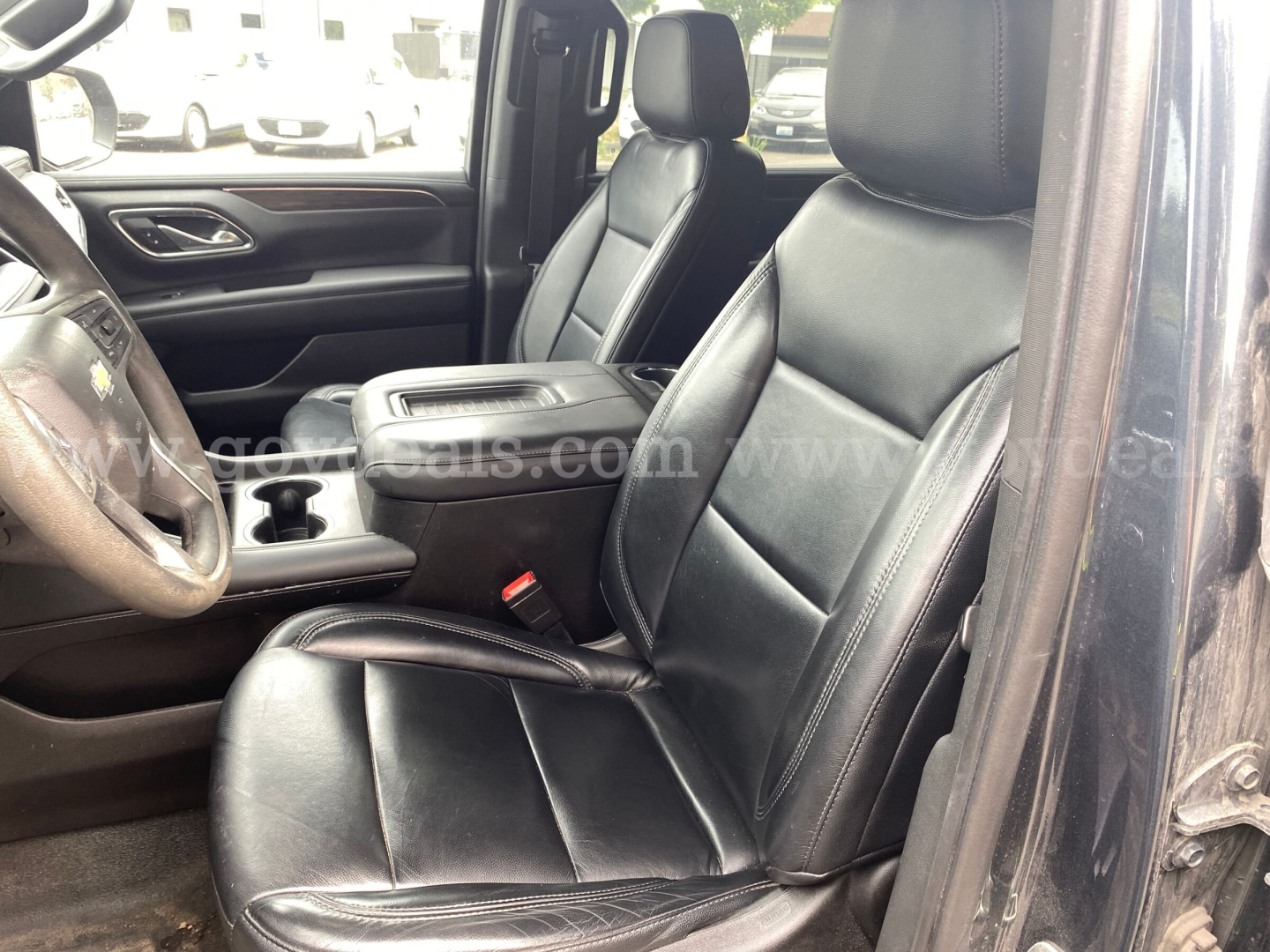 Interior front cabin of a 2021 Chevrolet Suburban with black leather seats, driver and front passenger seats, center console, and steering wheel visible.