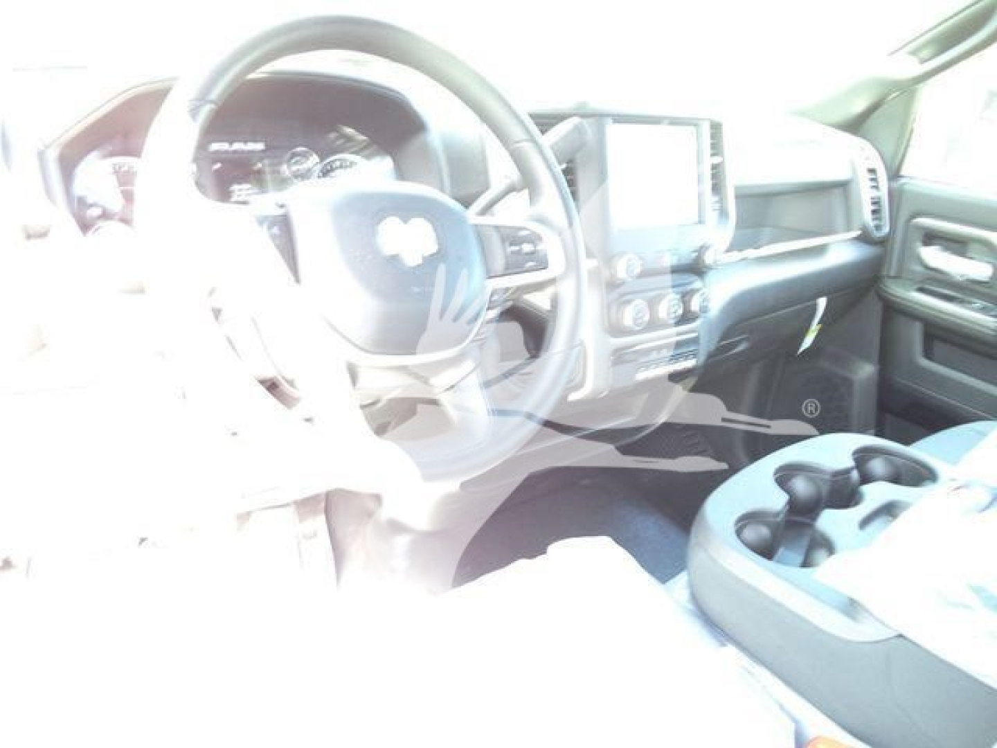 Ram 5500 cab interior showing steering wheel, dashboard, and center console; touchscreen display and cup holders visible