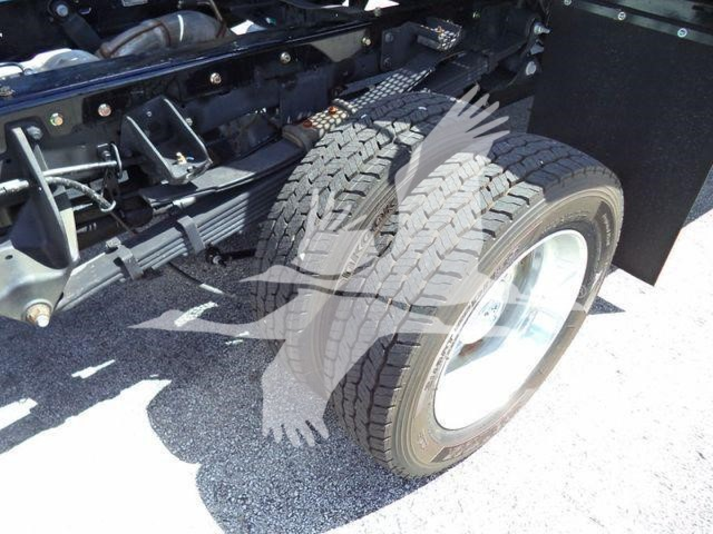 Dual rear wheel of a Ram 5500 rollback truck showing tire treads and chassis components.