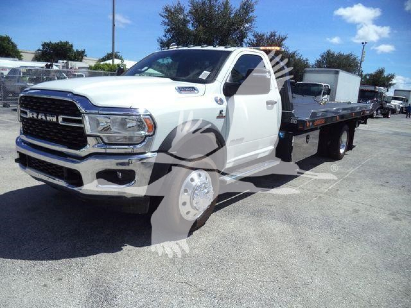 Ram 5500 Rollback truck in white with flatbed, front grille and headlights visible.