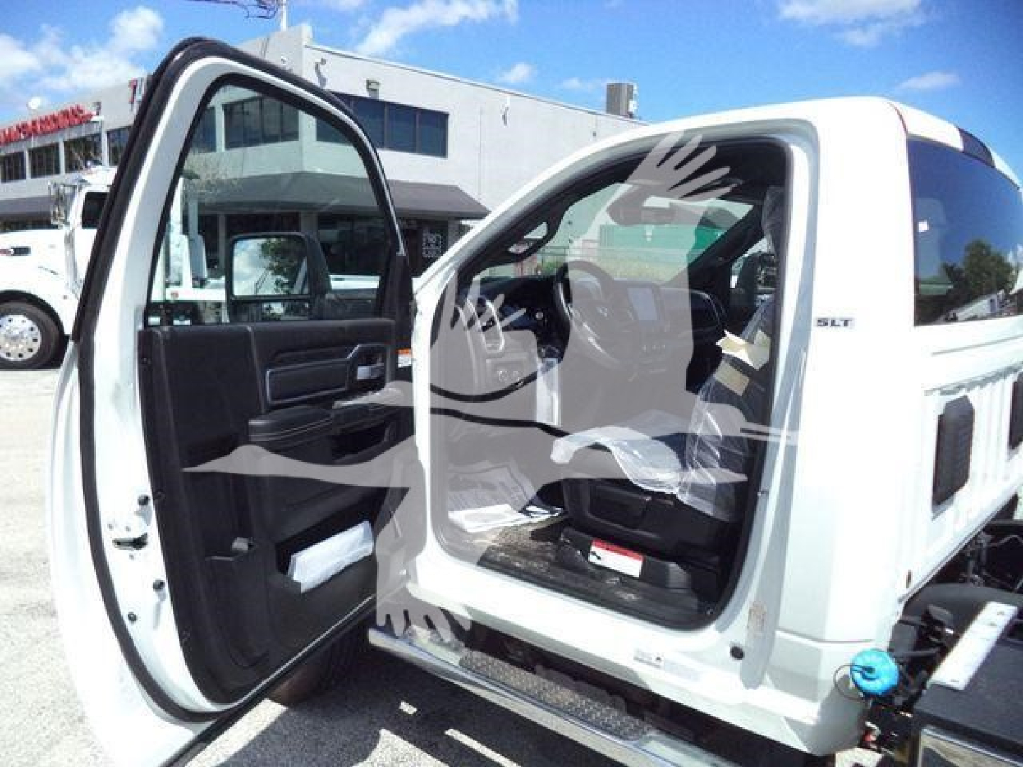 Ram 5500 SLT rollover truck cab interior view with rear passenger door open, white exterior, dashboard and seating visible.