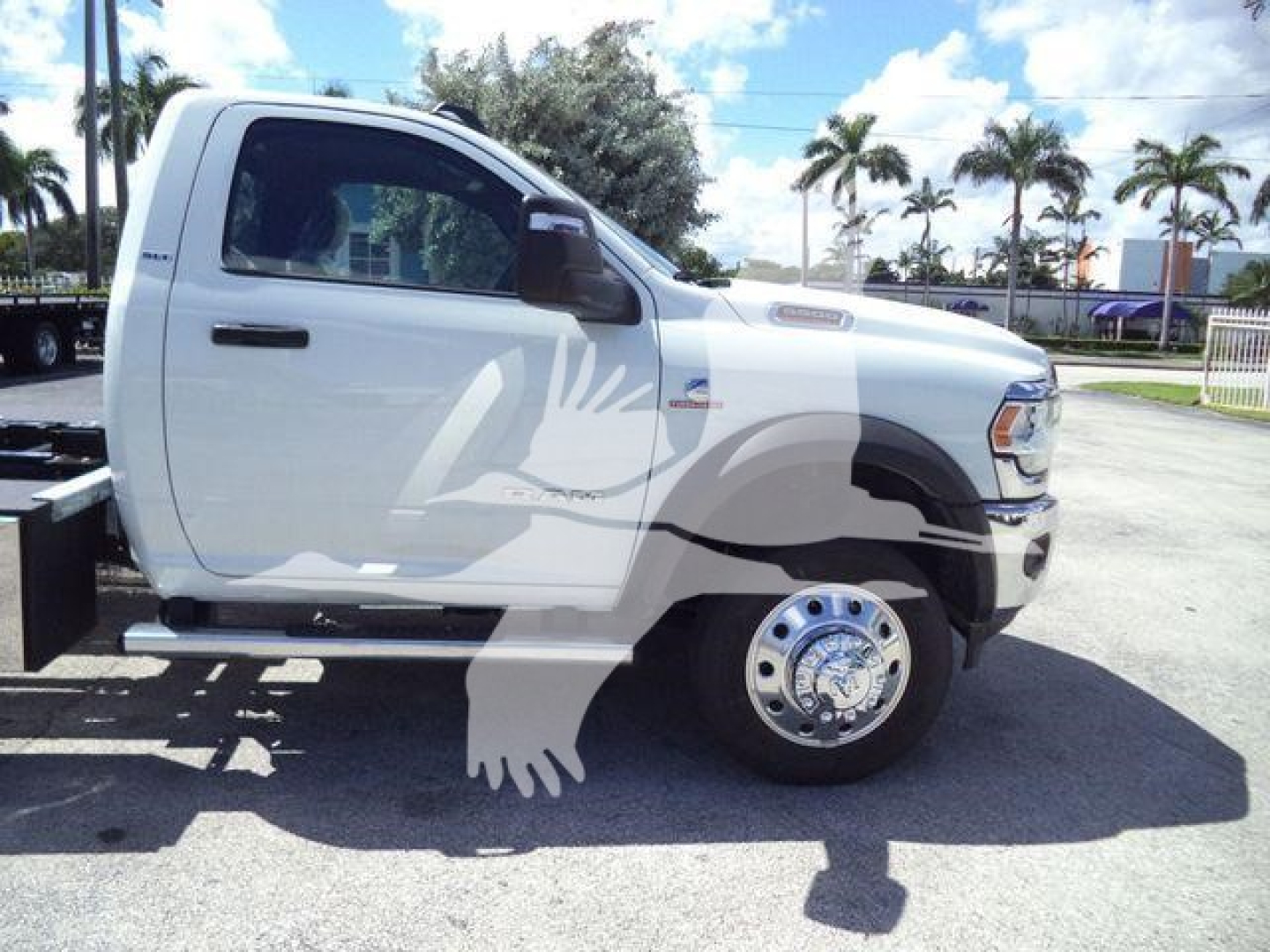 Ram 5500 rollback truck cab side view with decals and chrome wheel, white body, side step and emblem visible.