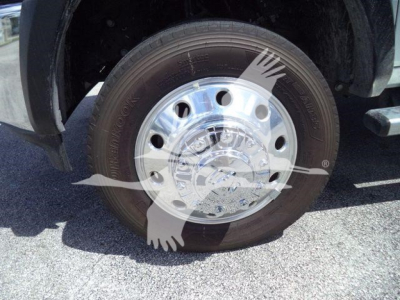 Truck wheel with chrome hubcap and tire, front wheel area of a Ram 5500 rollback truck.