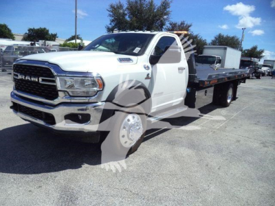 Ram 5500 Rollback truck in white with flatbed, front grille and headlights visible.